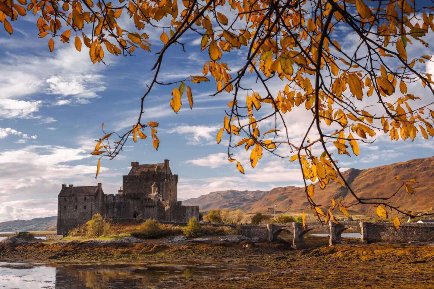 Το Κάστρο Eilean Donan στα Scottish Highlands με πέτρινη γέφυρα και φθινοπωρινό τοπίο