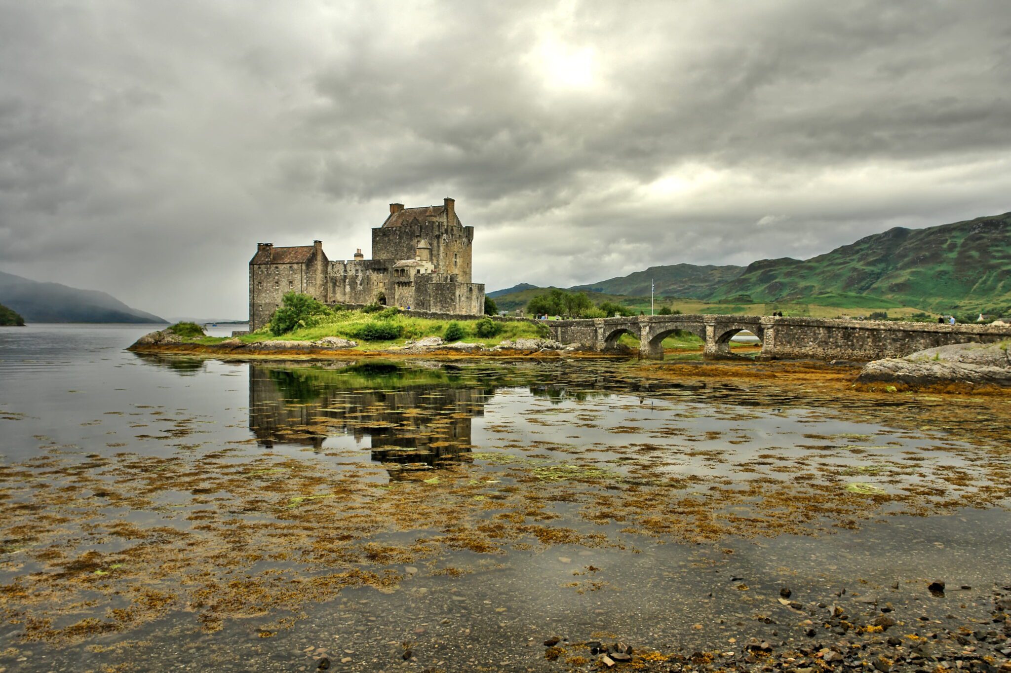 Το Κάστρο Eilean Donan με την πέτρινη γέφυρα, τη λίμνη και τα βουνά των Scottish Highlands
